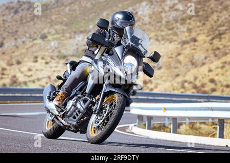 motociclista che prende una curva affilata sulla sua moto. Fotografia scattata nel porto di Navalmoral, provincia della città di Avila, Spagna, durante il giorno Settem Foto Stock