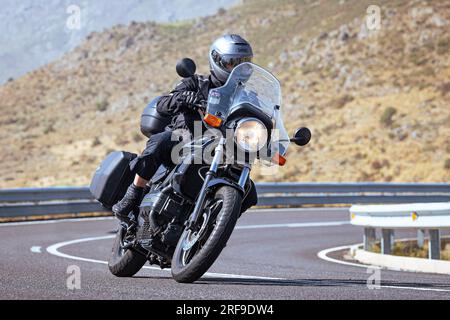 motociclista che prende una curva affilata sulla sua moto. Fotografia scattata nel porto di Navalmoral, provincia della città di Avila, Spagna, durante il giorno Settem Foto Stock