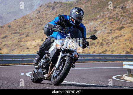 motociclista che prende una curva affilata sulla sua moto. Fotografia scattata nel porto di Navalmoral, provincia della città di Avila, Spagna, durante il giorno Settem Foto Stock