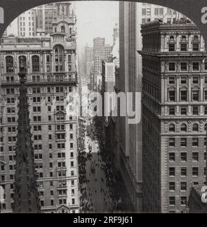 New York, New York: c. 1917. Guardando a nord su Broadway, oltrepassa la Trinity Church dall'Empire Building nel quartiere finanziario. L'Equitable Building di 38 piani, costruito nel 1915, è il secondo sulla destra e porzioni degli edifici Woolworth e Singer possono essere viste sulla sinistra. Foto Stock