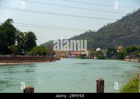 28 giugno 2022, Uttarakhand India. Città Santa Haridwar: Una splendida cattura del fiume Gange che scorre tra le maestose montagne e i sacri ghat balneari. Foto Stock