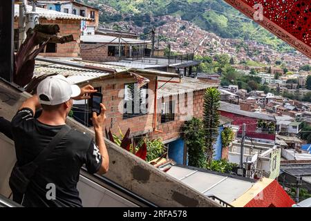 Medellin, Colombia. 1 agosto 2023. Un turista scatta una foto durante una visita al quartiere Comuna 13 a Medellin, Colombia, il 1 agosto 2023. In passato Comuna 13 era una delle aree più pericolose e violente di Medellin, oggi è un fiorente quartiere famoso per i suoi numerosi murales, artisti di graffiti e musica. (Foto di Ronen Tivony/Sipa USA) *** si prega di utilizzare il credito dal campo di credito *** credito: SIPA USA/Alamy Live News Foto Stock