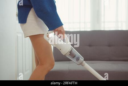 Donna che aspira mobili in una casa con un aspirapolvere portatile  portatile portatile Foto stock - Alamy