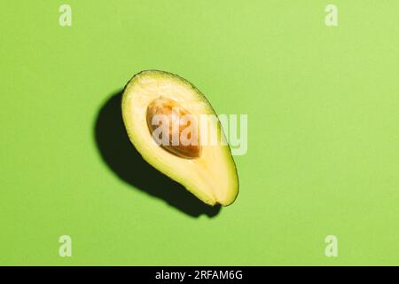 Primo piano dell'avocado dimezzato e dello spazio di copia su sfondo verde Foto Stock