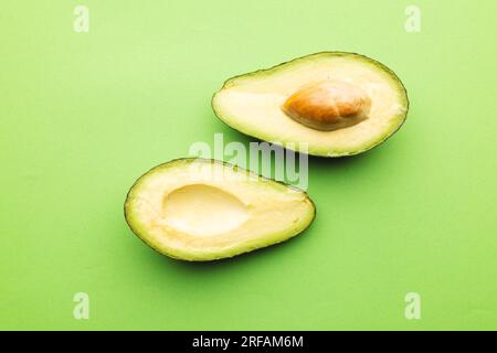 Primo piano di due metà di avocado e spazio di copia su sfondo verde Foto Stock