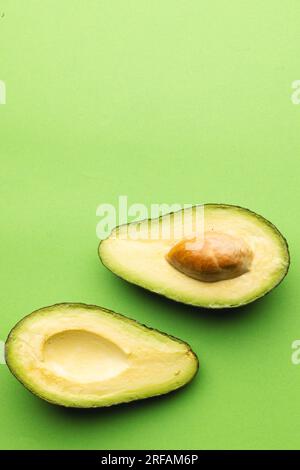 Primo piano di due metà di avocado e spazio di copia su sfondo verde Foto Stock