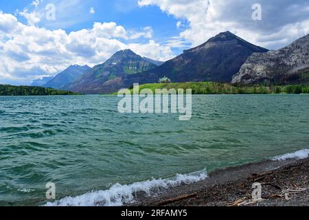 vista spettacolare delle montagne e dell'iconico hotel prince of wales attraverso i laghi di waterton color turchese in estate da waterton, alberta, canada Foto Stock