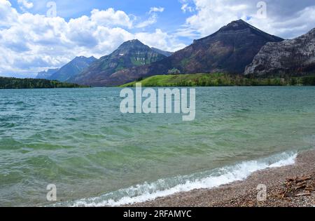 vista spettacolare delle montagne e dell'iconico hotel prince of wales attraverso i laghi di waterton color turchese in estate da waterton, alberta, canada Foto Stock