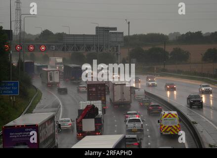 Traffico lento in caso di forte pioggia sulla M62 vicino a Brighouse nel West Yorkshire, poiché il Met Office ha emesso un avvertimento meteorologico giallo attraverso le Midlands per i temporali e il sud dell'Inghilterra per i forti venti. Data foto: Mercoledì 2 agosto 2023. Foto Stock