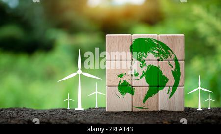 Blocchi di legno impilati con icona a forma di globo e mulino a vento su sfondo naturale. E' un concetto che aiuta a preservare l'ambiente. Concetto di salvare il mondo. Foto Stock