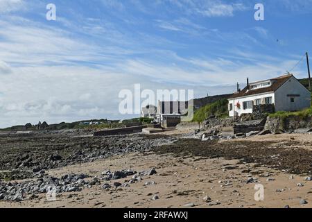 Port Eynon Beach sulla costa di Gower in una giornata di sole ad agosto e mostra il cottage, le rampe, il Salthouse e l'estremità superiore della spiaggia con le rocce Foto Stock