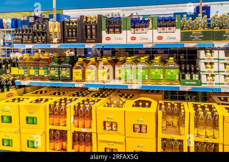 Italia - 01 agosto 2023: Semi e olio d'oliva in bottiglie di plastica e vetro in confezioni esposte sugli scaffali in vendita in un supermercato italiano a prezzi scontati Foto Stock