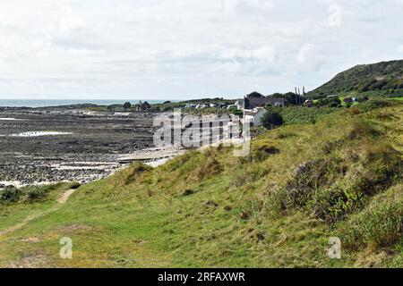 Parte della spiaggia di Port Eynon sulla costa della penisola di Gower che mostra una sezione della spiaggia insieme a rocce, piscine, sabbia e il Salthouse Foto Stock