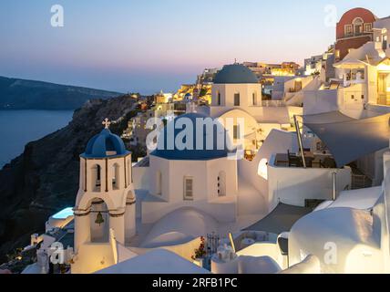 Due chiese con cupola blu - Agios Spiridonas (San Spyridon) e Chiesa di Anastasi (Resurrezione) - al calar della notte, Ia (Oia), Santorini, Grecia Foto Stock