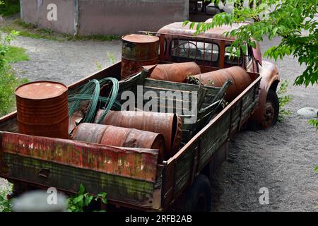 Vecchio veicolo arrugginito con serbatoi di benzina arrugginiti. Foto Stock