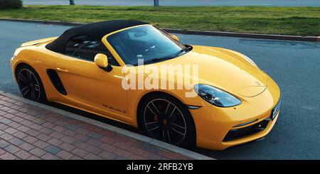 San Pietroburgo, Russia - 30 luglio 2023: Auto gialla Porsche 718 Boxster S su una strada cittadina Foto Stock