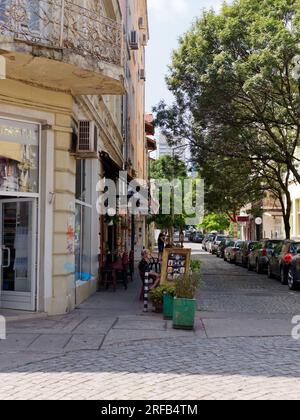 Strada acciottolata alberata dall'architettura autentica con balconi nella città di Sofia, Bulgaria. 2 agosto 2023. Foto Stock