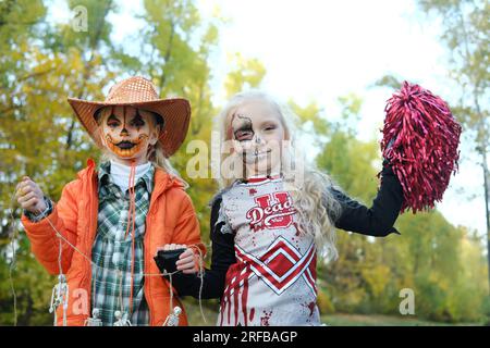 Una ragazza con un costume da cheerleader e un trucco a mezza faccia sotto  forma di scheletro celebra Halloween. Foto orizzontale Foto stock - Alamy