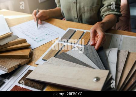 designer di interni che lavora a un nuovo progetto di progettazione di case in ufficio. scelta dei materiali e dei colori per pavimenti e mobili dai campioni Foto Stock