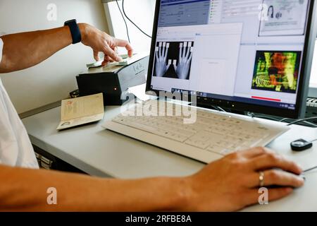 Norimberga, Germania. 2 agosto 2023. Un agente di polizia della polizia di frontiera bavarese dimostra un controllo dei passaporti all'aeroporto di Norimberga. La polizia di frontiera ha iniziato il suo lavoro il 1 luglio 2018. Credito: Daniel Löb/dpa/Alamy Live News Foto Stock