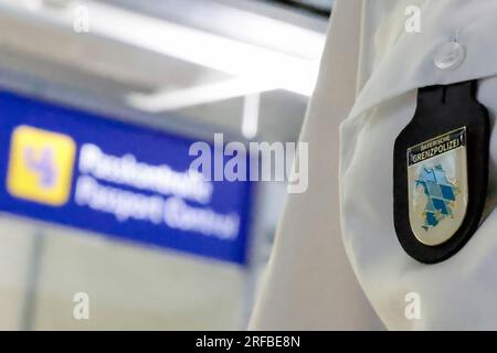 Norimberga, Germania. 2 agosto 2023. L'emblema del petto della polizia di frontiera bavarese - davanti a un cartello di controllo passaporti all'aeroporto di Norimberga. Credito: Daniel Löb/dpa/Alamy Live News Foto Stock