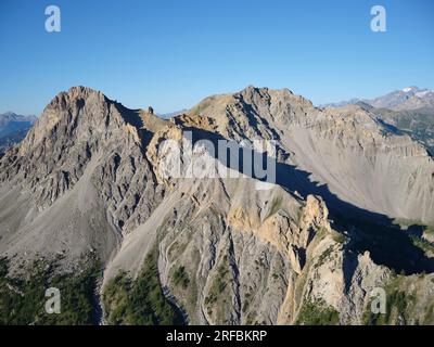 VISTA AEREA. Gravina del Mezzodi con roccia di Barrabas nell'alta Valle di Susa. Bardonecchia, città metropolitana di Torino, Piemonte, Italia. Foto Stock