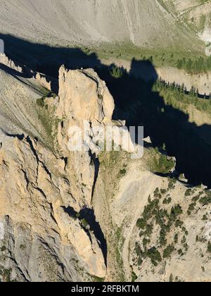 VISTA AEREA. Gravina del Mezzodi con roccia di Barrabas nell'alta Valle di Susa. Bardonecchia, città metropolitana di Torino, Piemonte, Italia. Foto Stock