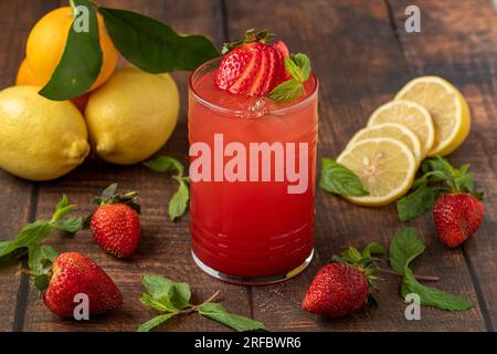 Limonata di fragole ghiacciate in vetro su tavolo di legno Foto Stock