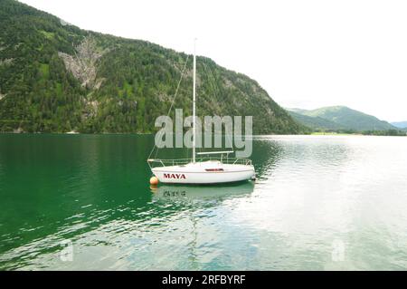 Barca sul lago Achensee in Austria, il lago riflette la montagna verde e prende il colore verde. Foto Stock