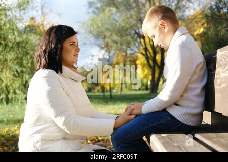 Madre guarda suo figlio sconvolto e ascolta i suoi problemi. Foto orizzontale Foto Stock