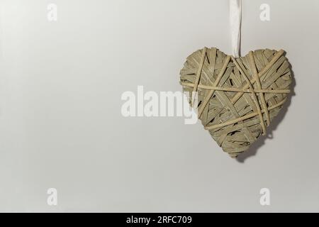 Cuore intrecciato su sfondo grigio - tema Love and St. San Valentino. Copia spazio. Un cuore grigio. Foto Stock