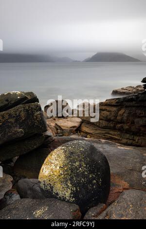 Costa rocciosa a Elgol, affacciata sul Loch Scavaig fino al Black Cuillin avvolto dalla nebbia Foto Stock