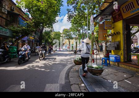 Hanoi, Vietnam - 28 maggio 2023: Le incantevoli strade della città vecchia rivelano un vivace tableau: Motociclette e biciclette che sfrecciano, creando un cacophon melodico Foto Stock