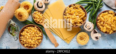 Assortimento di diversi tipi di pasta, funghi e fagioli verdi su sfondo azzurro Foto Stock