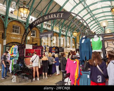 Gente che fa shopping alle bancarelle del mercato nella parte del mercato Apple di Covent Garden, Londra, Regno Unito Foto Stock