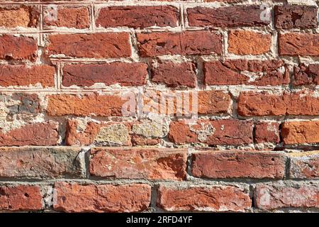 Antica parete scheggiata in mattoni di argilla rossa. Sfondo testurizzato di alta qualità per il design Foto Stock