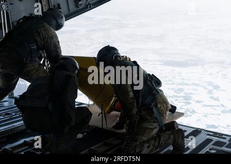 Da sinistra a destra, Alaska Air National Guard Senior Master Sgt. Brian Johnson, Tech. Il Sgt. Chris Eggleston e il Senior Master Sgt. Cecil Dickerson, i caricatori assegnati al 144th Airlift Squadron presso la Joint base Elmendorf-Richardson, si preparano a dispiegare una boa di ghiaccio rialzabile Air-Deployable (AXIB) durante una missione di lancio sull'Oceano Artico, il 12 luglio 2023. L'Office of Naval Research ha collaborato con la 144th AS per distribuire cinque diversi tipi di boe di raccolta dati in oltre 1.000 miglia nautiche dell'Oceano Artico. (STATI UNITI Foto dell'aeronautica militare di Airman 1st Class Shelimar Rivera Rosad Foto Stock