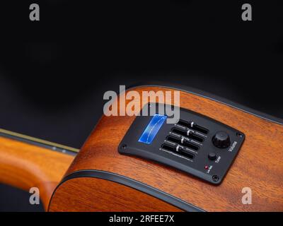 Primo piano del pickup EQ della chitarra acustica con sintonizzatore e messa a fuoco selettiva Foto Stock