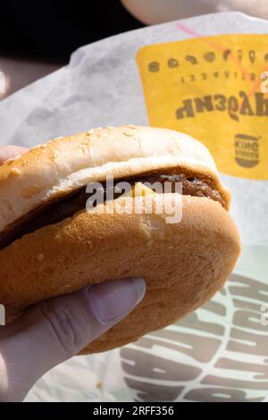 Minsk, Bielorussia - 20 aprile 2023: Cheeseburger in mano al Burger King primo piano Foto Stock