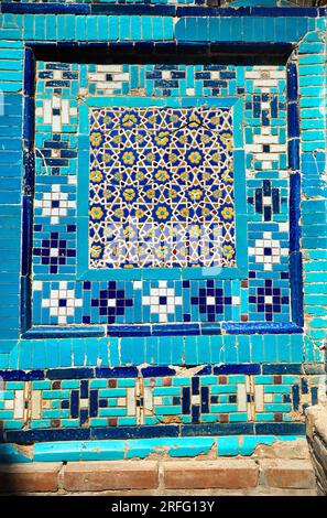 Mosaico sulle pareti del bellissimo cimitero storico di Shahi Zinda con parete e arco finemente decorati da mausolei in pietra blu e turchese Foto Stock