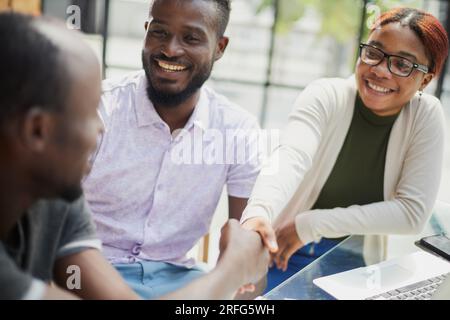 Creazione di una nuova applicazione in un team. i giovani programmatori si siedono a tavola Foto Stock