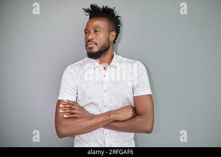 Un uomo d'affari serio dalla pelle scura ha un aspetto rigoroso, contempla nuovi progetti aziendali Foto Stock