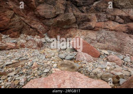 Pietre rosse sulla riva dell'Oceano Atlantico Foto Stock