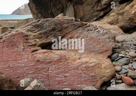 Pietre rosse sulla riva dell'Oceano Atlantico Foto Stock