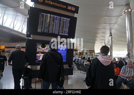 Aeroporto di Londra Heathrow, Inghilterra Terminal due passeggeri che guardano l'imbarco partenze Foto Stock