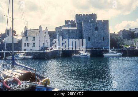 Foto d'archivio del 1989 del castello di Rushen e delle armi del castello viste attraverso il porto di Castletown sull'isola di Man. Foto Stock