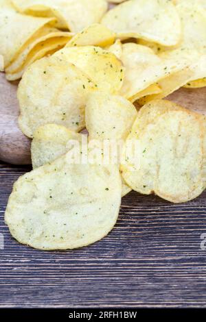 patatine sottili con spezie e sale, patatine fritte in olio e cosparse di spezie, fast food dannosi Foto Stock