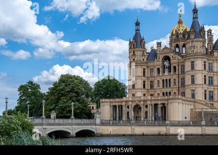 schwerin, Meclemburgo-Vorpommern Germania, 07 06 2023: Veduta di parte del castello di Schwerin contro un cielo blu e un ponte sul lago Schwerin Foto Stock