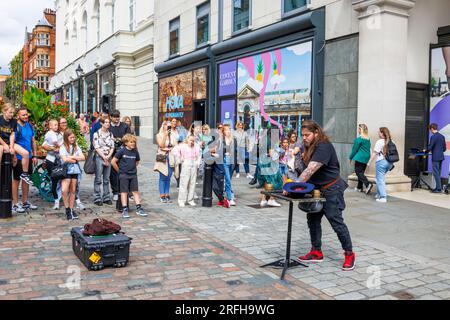 Il mago di strada australiano Jason Maher si esibisce e intrattiene una folla al Covent Garden nel West End di Londra, WC2 Foto Stock