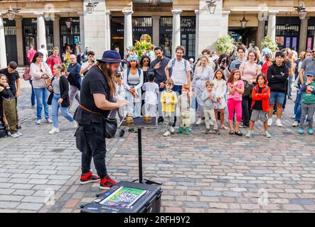 Il mago australiano Jason Maher si esibisce e intrattiene una folla al Covent Garden nel West End di Londra, WC2 Foto Stock